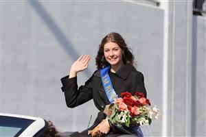 Photo of Samantha Gearhart waving in the Harvest of Harmony parade as the Islander queen candidate